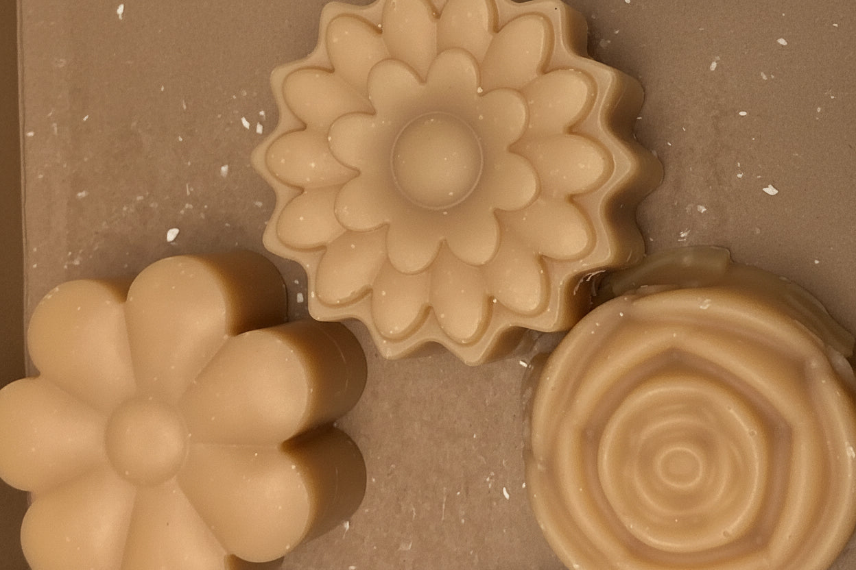 Three flower-shaped soap bars with different designs on a beige background
